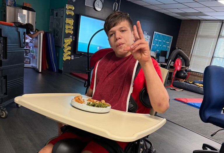 Student Victor using the donated adaptive wheelchair